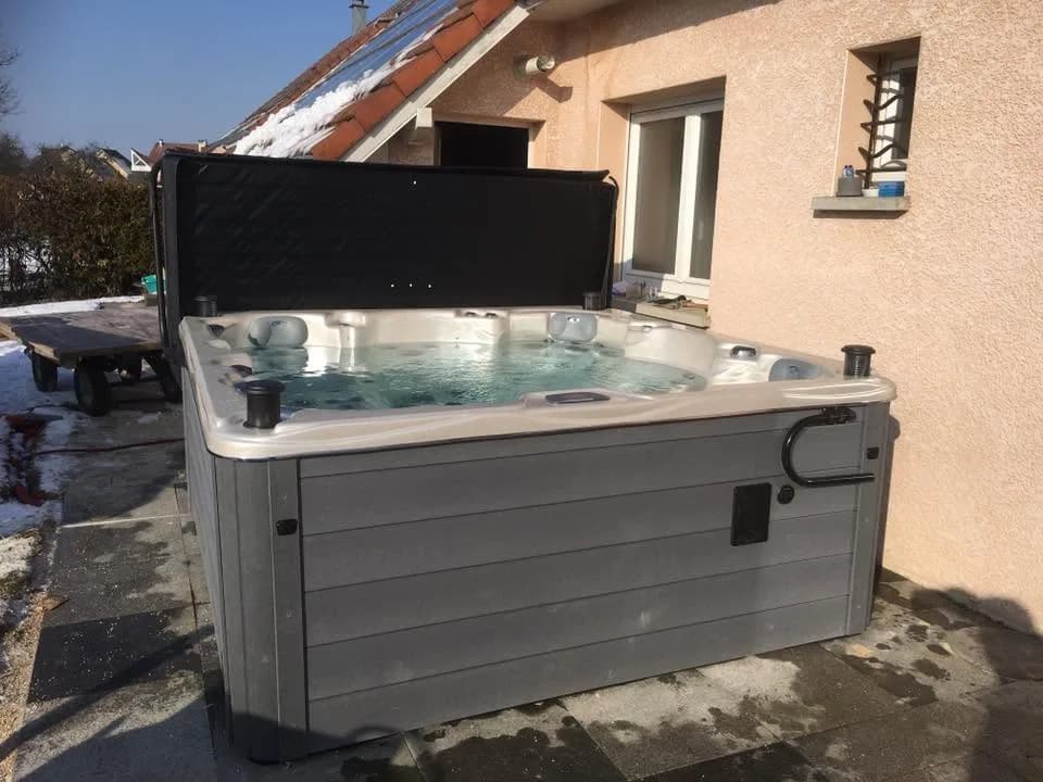 Installation d'un spa Vancouver Full option dans le Doubs, sur une terrasse dans la neige, lève-couverture