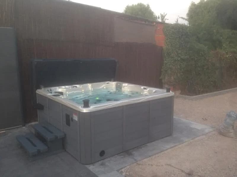 Installation d'un spa Vancouver Full option dans le Nord, sur une dalle devant une palissade en bois