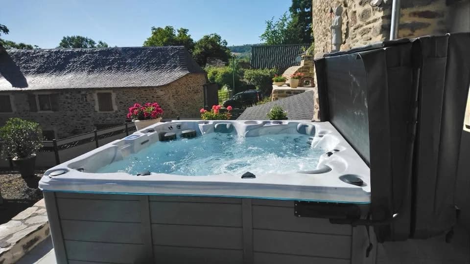 Installation d'un spa Vancouver Full option en Aveyron, sur une terrasse dallée, vue sur la campagne