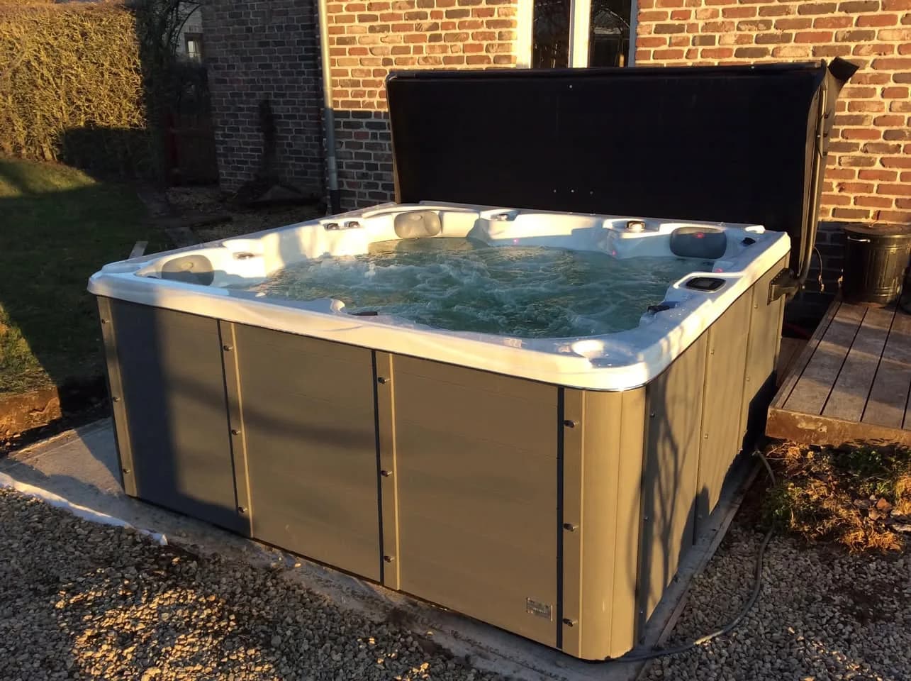 Installation d'un spa Vancouver Full option à Feschaux, sur du gravier près d'une terrasse en bois
