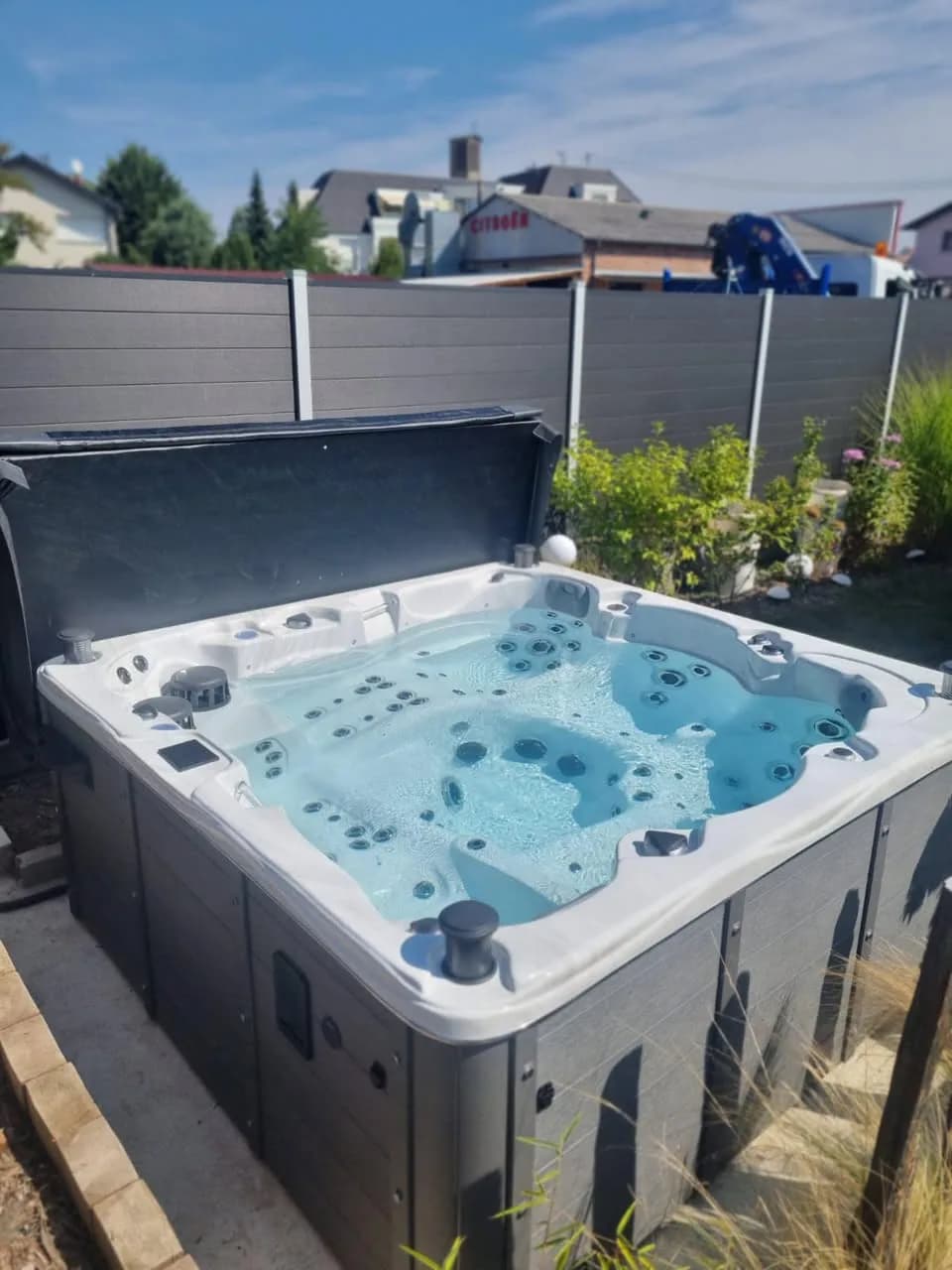 Installation d'un spa Vancouver Full option à Gambsheim, dans un jardin paysager, lève-couverture