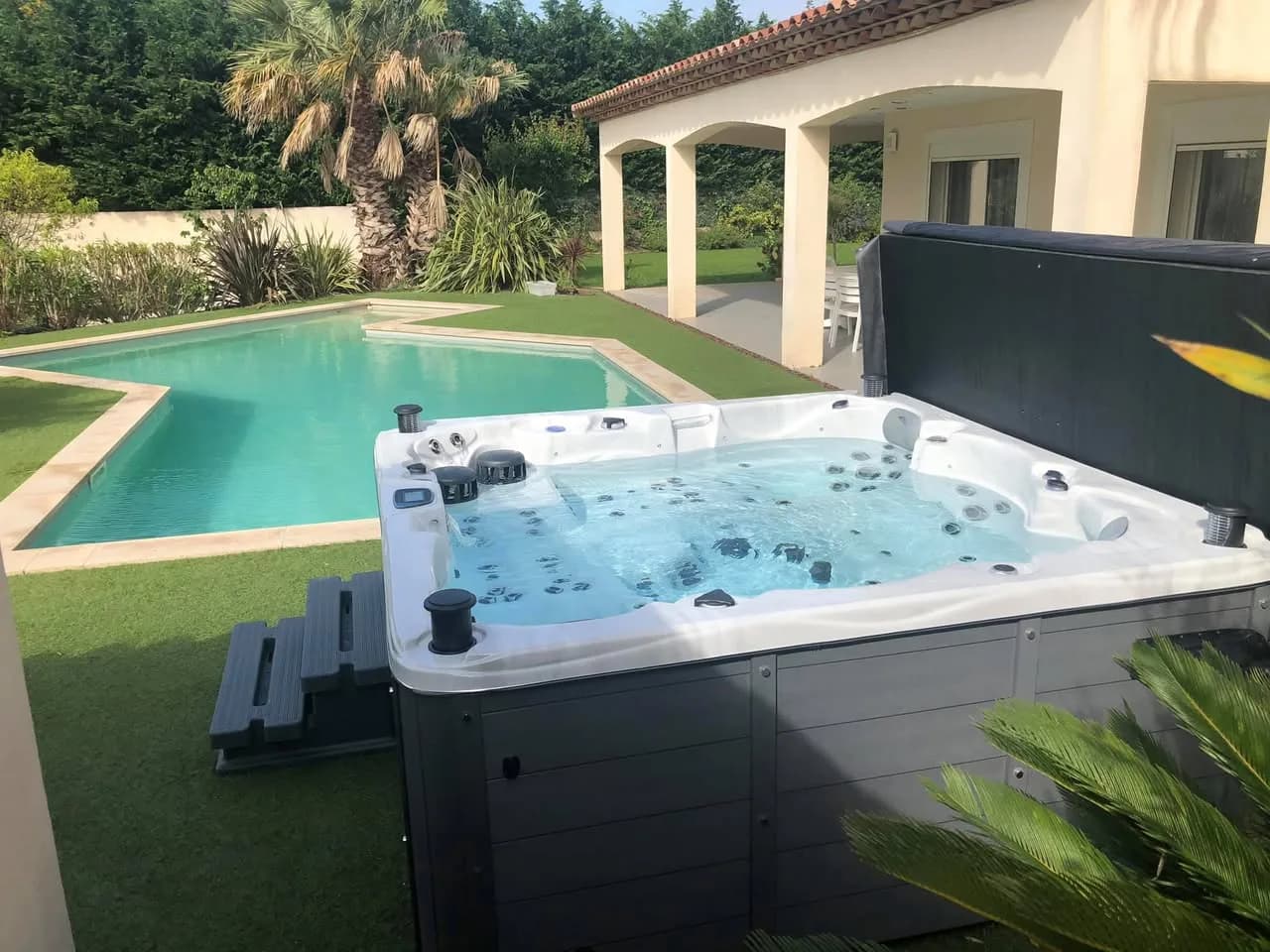Installation d'un spa Vancouver Full option à Istres, au bord d'une piscine, sur une pelouse synthétique