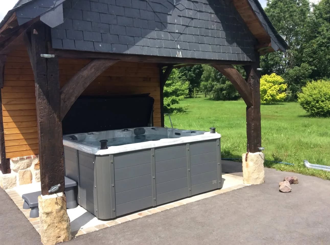 Installation d'un spa Vancouver Full option à La Salle, sous un préau en bois ouvert sur le jardin