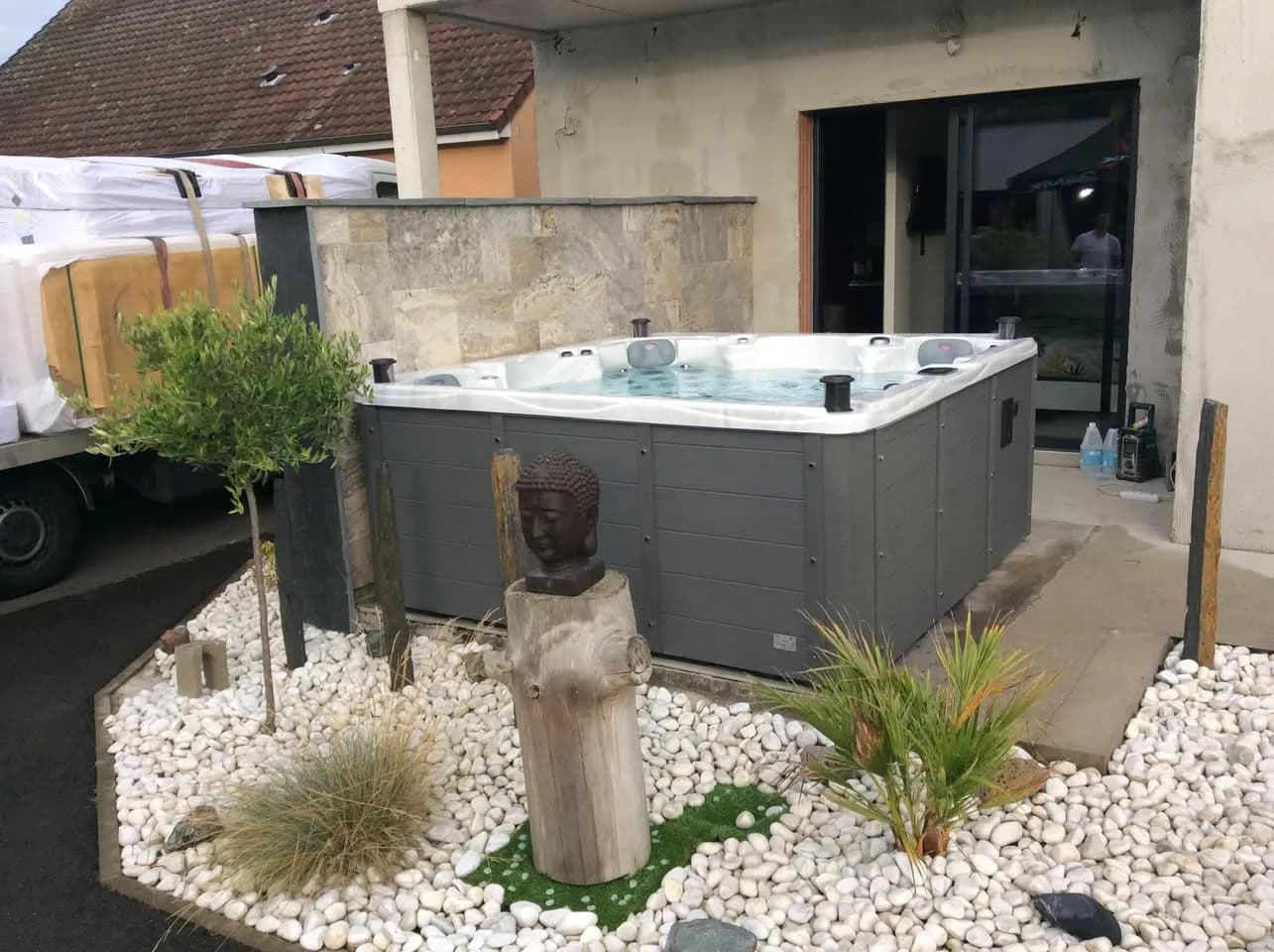 Installation d'un spa Vancouver Full option à Le Breil-sur-Mérize, sur une dalle entourée de galets blancs