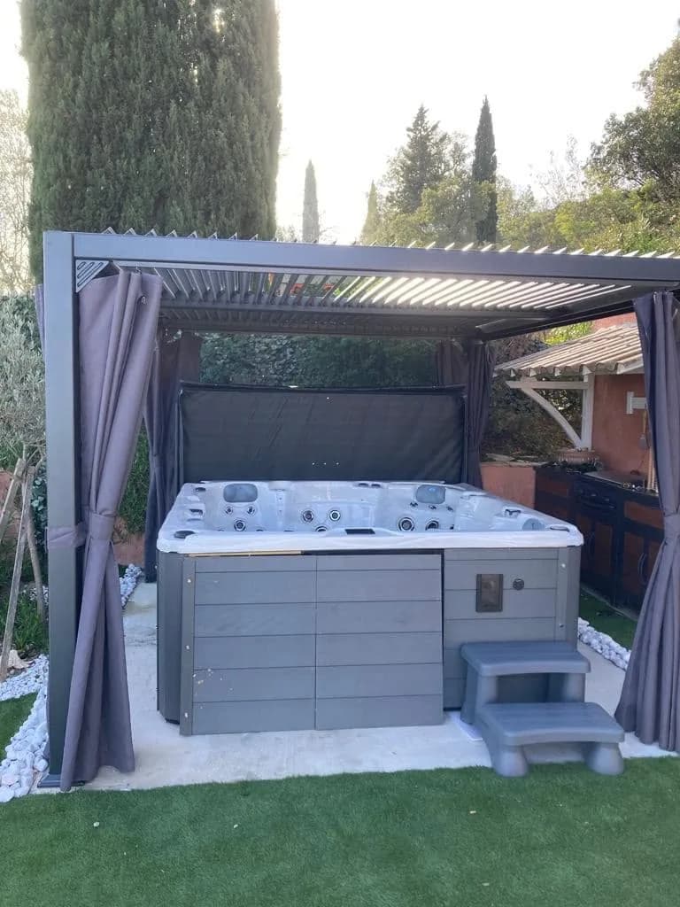 Installation d'un spa Vancouver Full option à Le Muy, sous une pergola à rideaux, marchepied