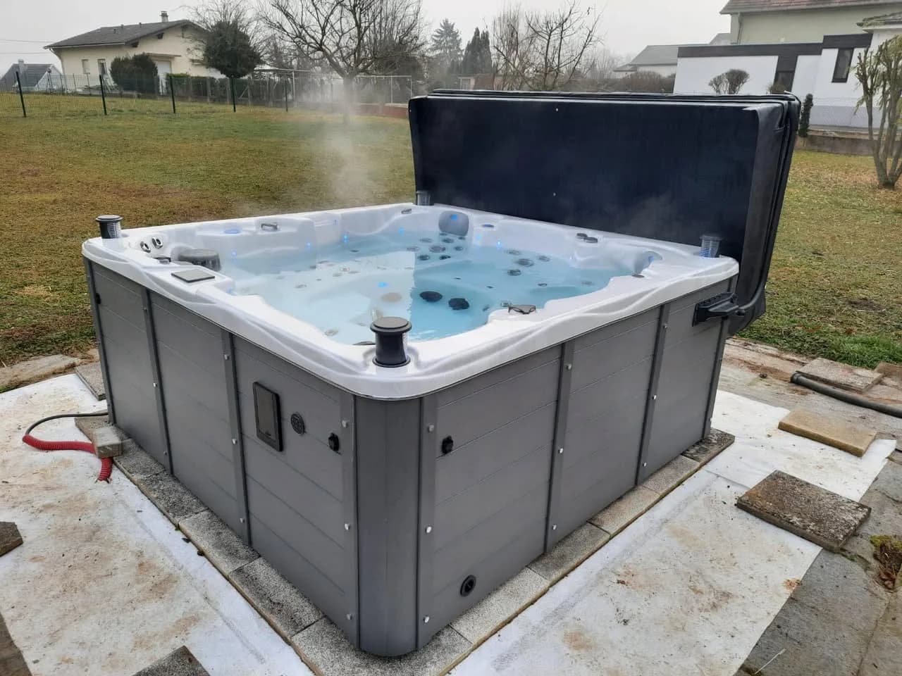 Installation d'un spa Vancouver Full option à Morschwiller-le-Bas, sur une dalle dans le gazon, lève-couverture