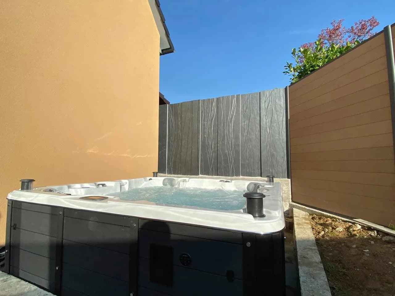 Installation d'un spa Vancouver Full option à Mothern, sur une dalle entre un mur et des palissades