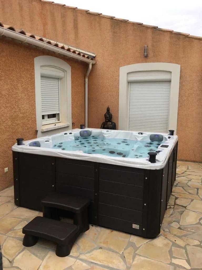 Installation d'un spa Vancouver Full option à Narbonne, sur un dallage en pierre, tablier marron