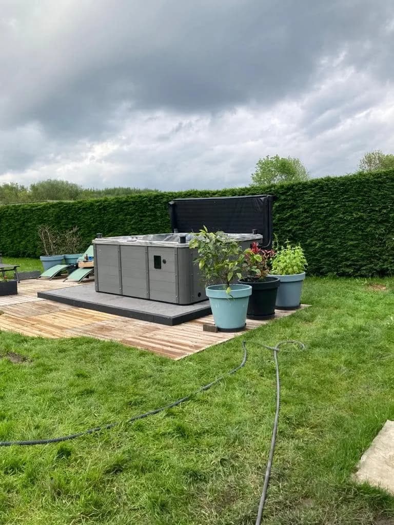 Installation d'un spa Vancouver Full option à Quaregnon, sur une plateforme en bois dans une pelouse