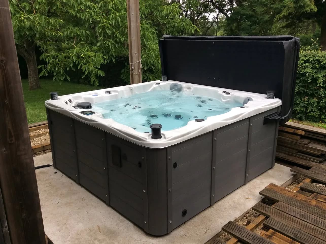 Installation d'un spa Vancouver Full option à Saint-Arnoult-en-Yvelines, sur une terrasse en bois dans un jardin arboré