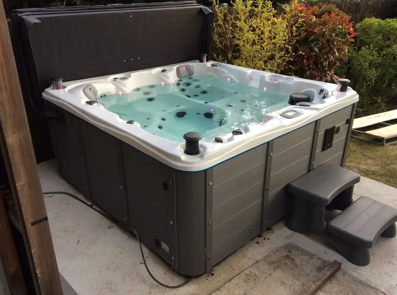 Installation d'un spa Vancouver Full option à Saint-Cyr-sur-Loire, sur une dalle dans un jardin, marchepied