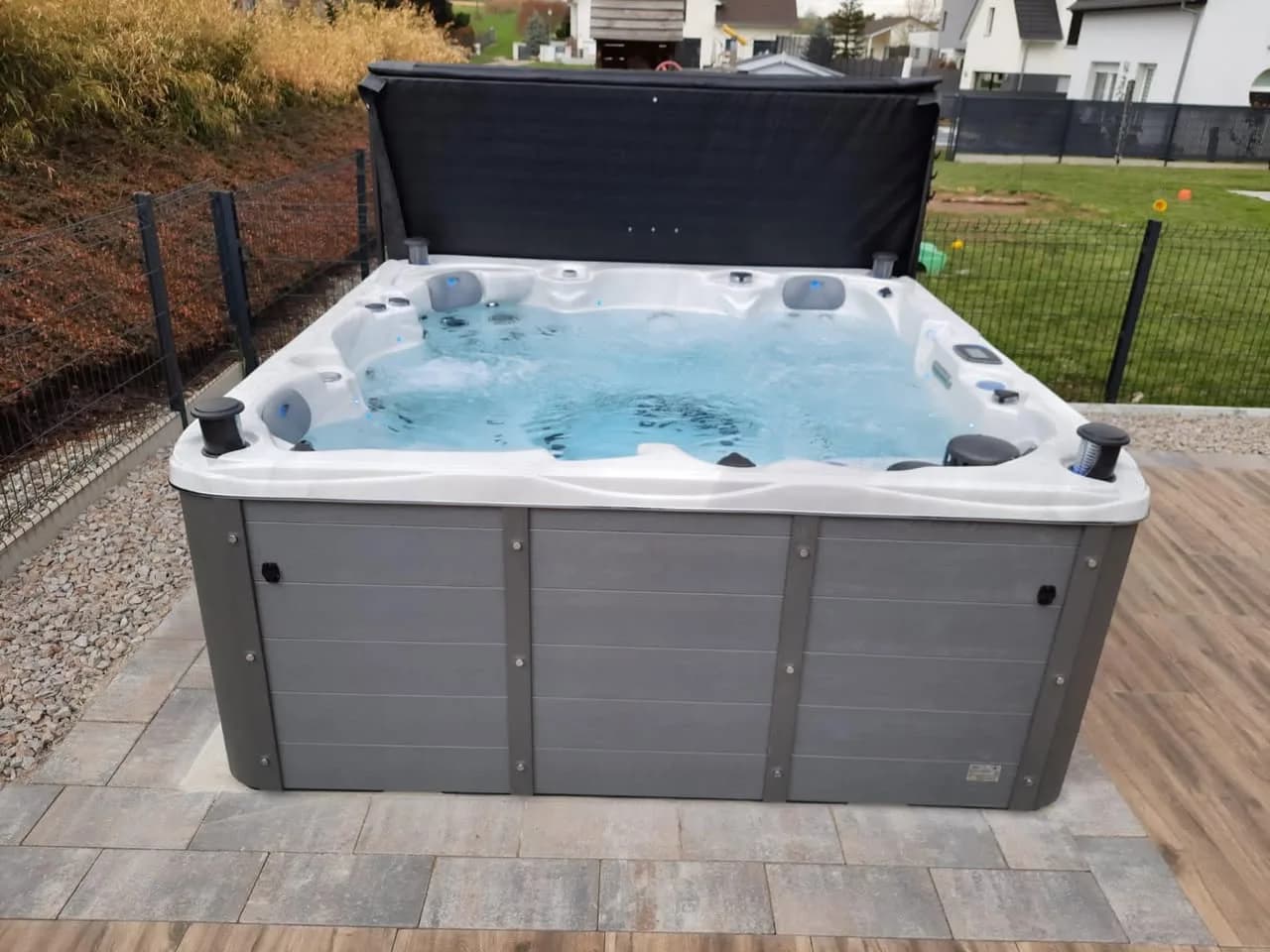 Installation d'un spa Vancouver Full option à Steinbrunn-le-Haut, sur une terrasse dallée, lève-couverture