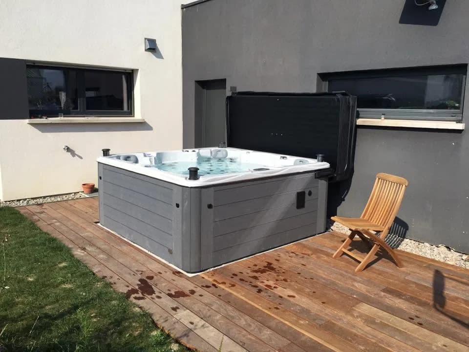 Installation d'un spa Vancouver Full option à Village-Neuf, sur une terrasse en bois, lève-couverture