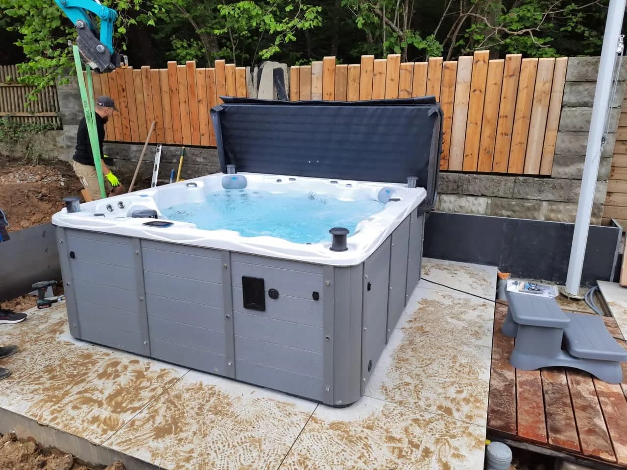 Installation d'un spa Vancouver Full option à Waldighofen, sur une dalle béton devant une palissade en bois
