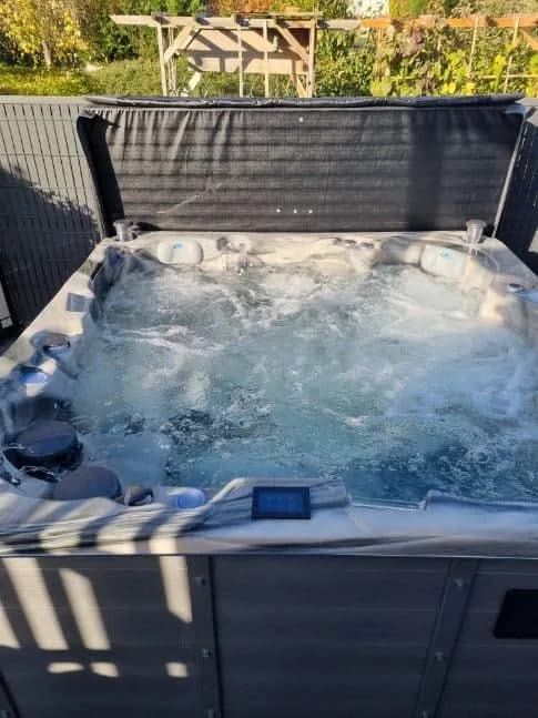 Installation d'un spa Vancouver Full option à Wittelsheim, dans un jardin, lève-couverture