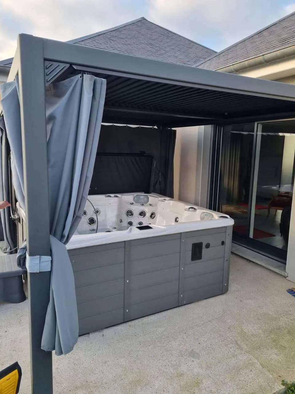 Installation d'un spa Vancouver à Gentelles, sous une tonnelle à rideaux