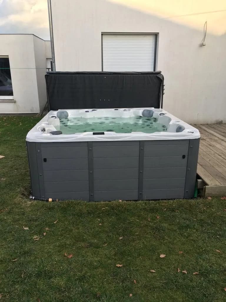 Installation d'un spa Vancouver à Genusson, au bord du gazon contre la maison