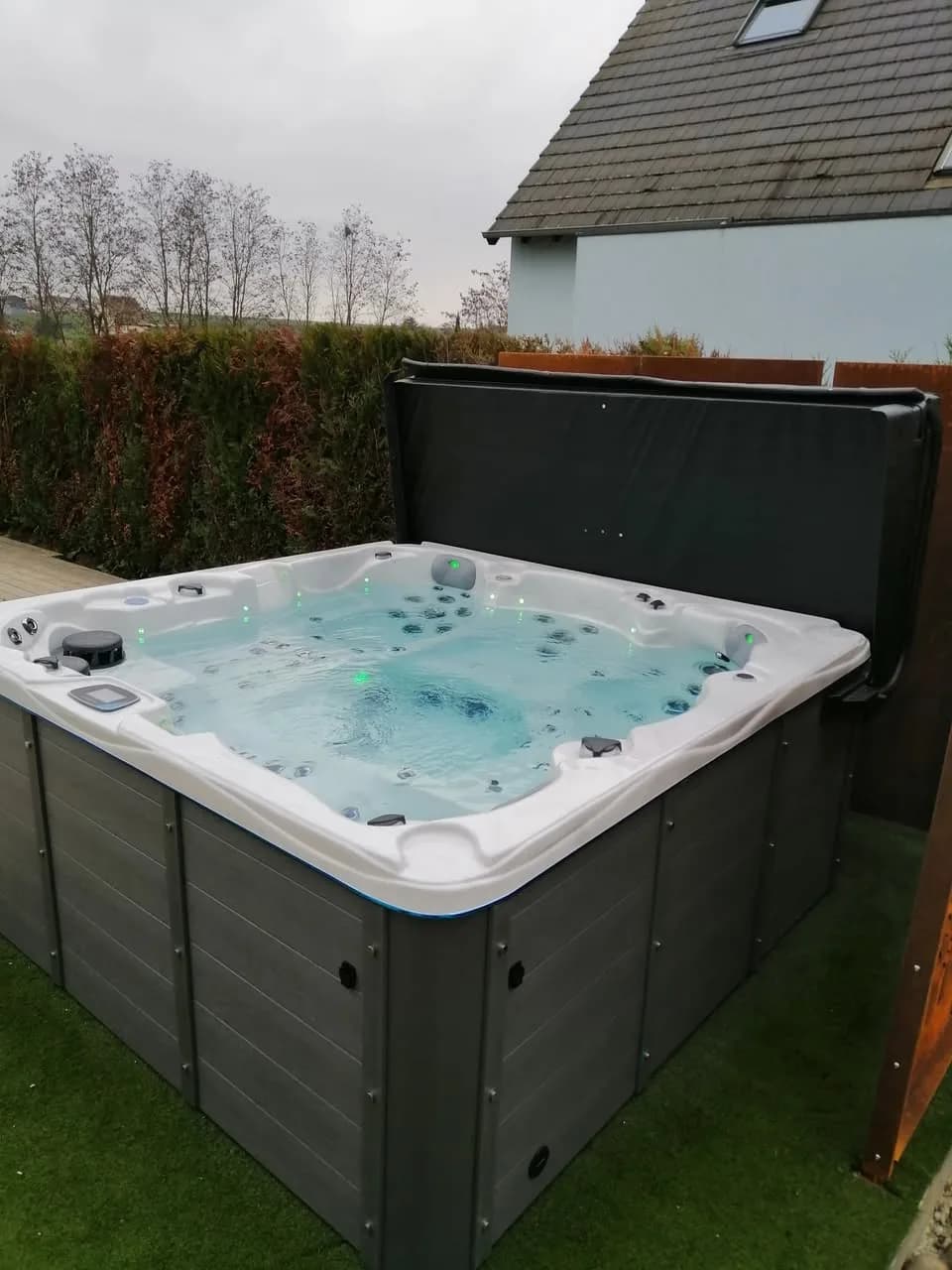 Installation d'un spa Vancouver à Kienheim, sur une pelouse synthétique, lève-couverture