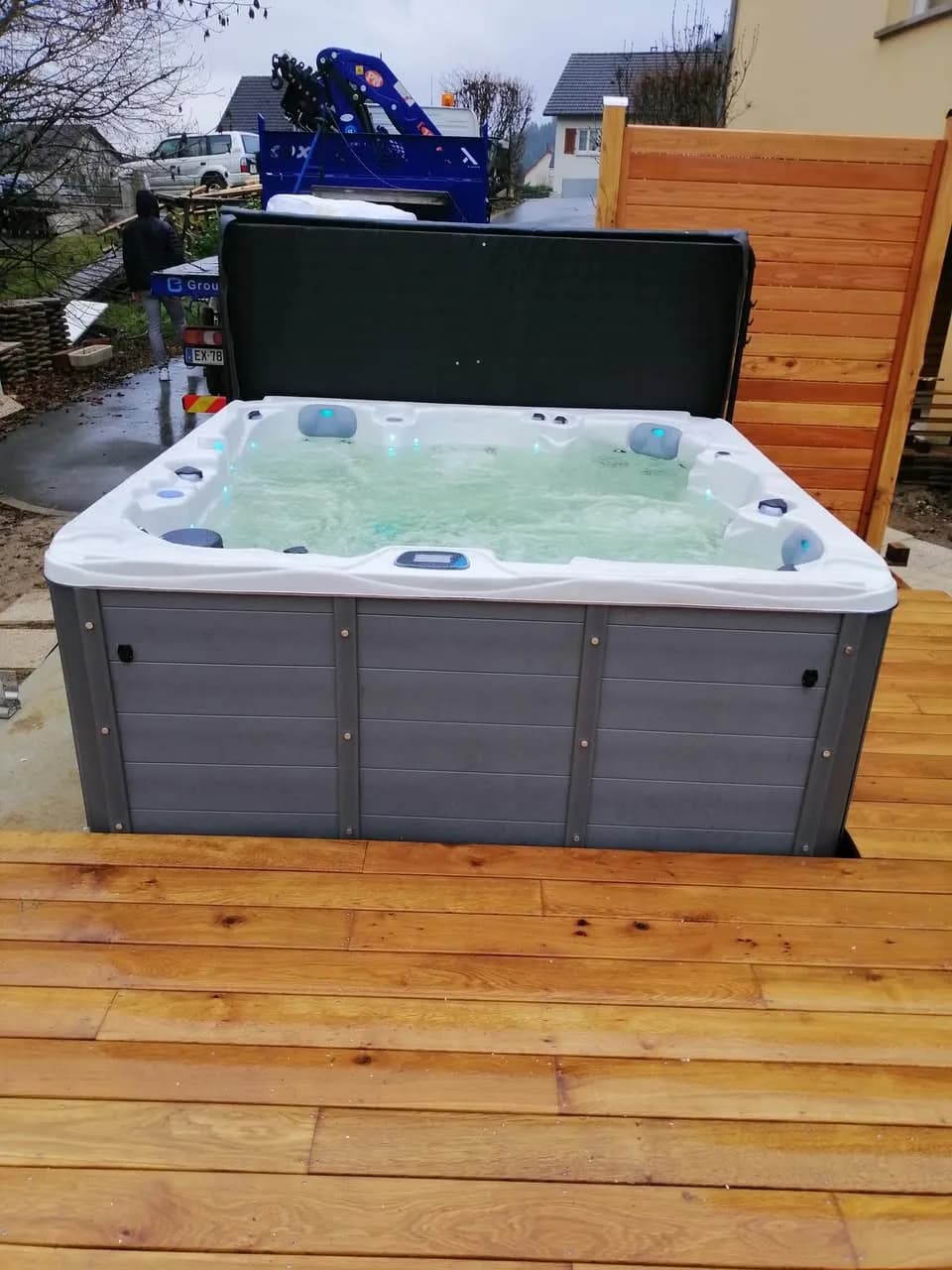 Installation d'un spa Vancouver à Kirchberg, sur une terrasse en bois, lève-couverture