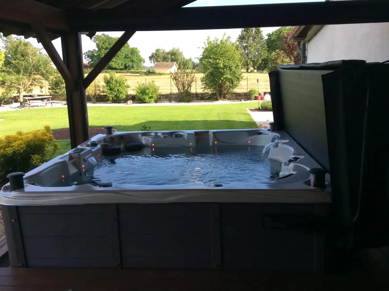 Installation d'un spa Vancouver à Mézériat, sous un abri en bois face au jardin