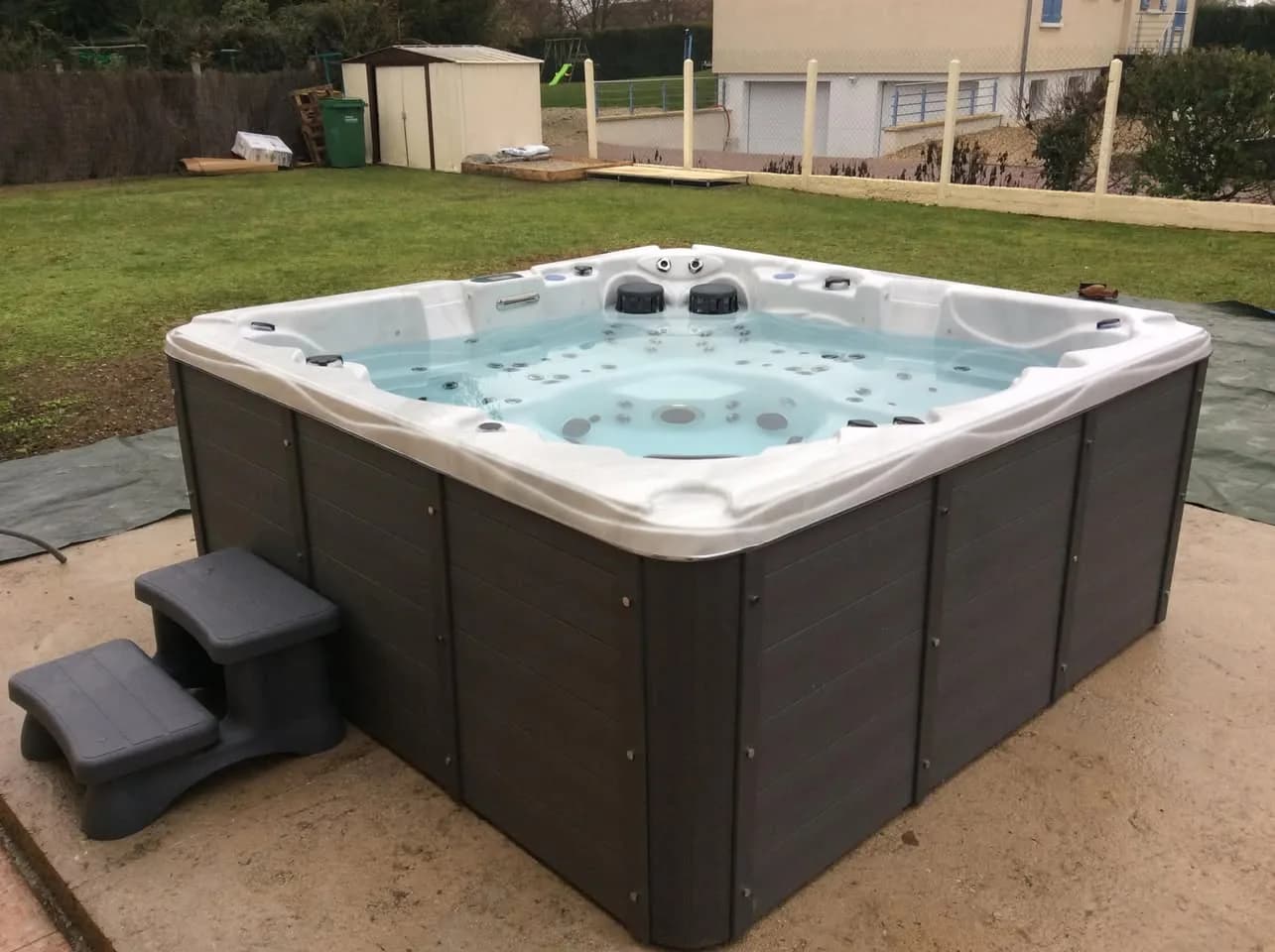 Installation d'un spa Vancouver à Rhinau, sur une dalle dans un jardin, marchepied