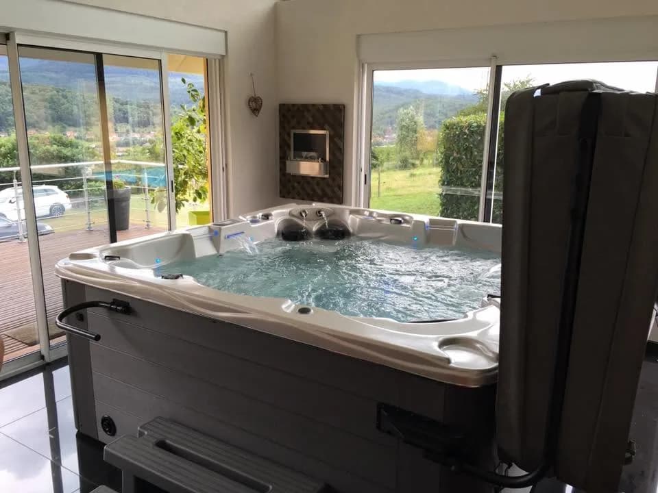 Installation d'un spa Vancouver à Russ, en intérieur, devant des baies vitrées