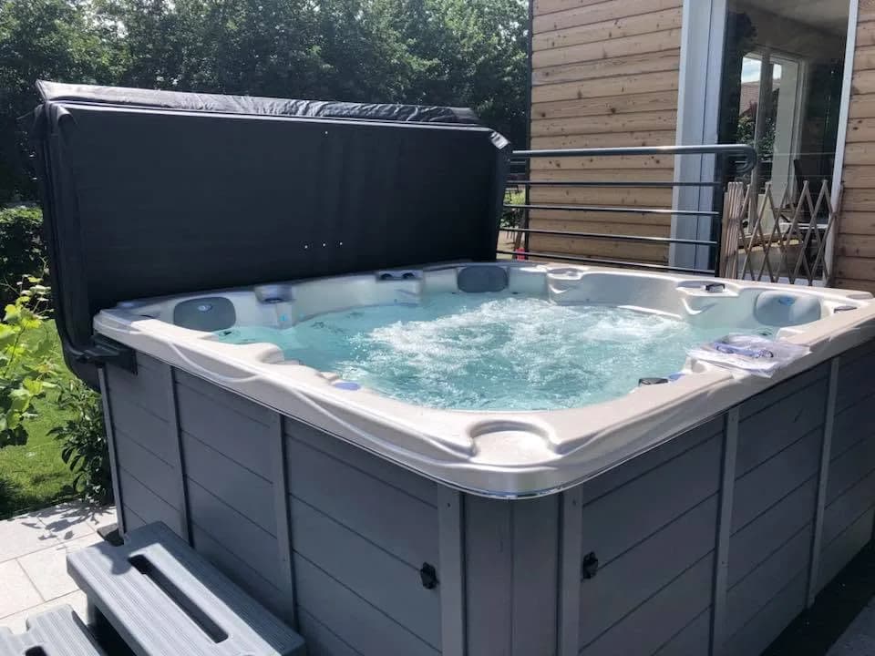 Installation d'un spa Vancouver à Saint-Étienne-lès-Remiremont, sur une terrasse, vue sur les collines boisées