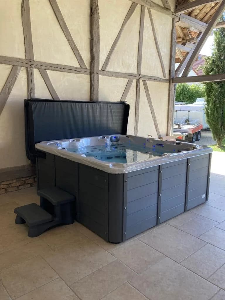 Installation d'un spa Vancouver à Saint-Germain, sous le préau d'un corps de ferme à colombages