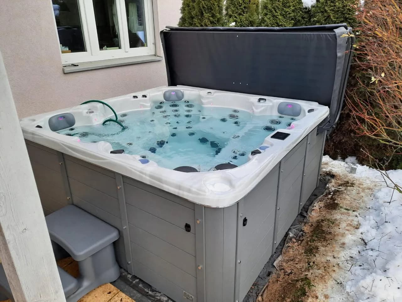 Installation d'un spa Vancouver à Val-de-Travers, dans un jardin enneigé, marchepied