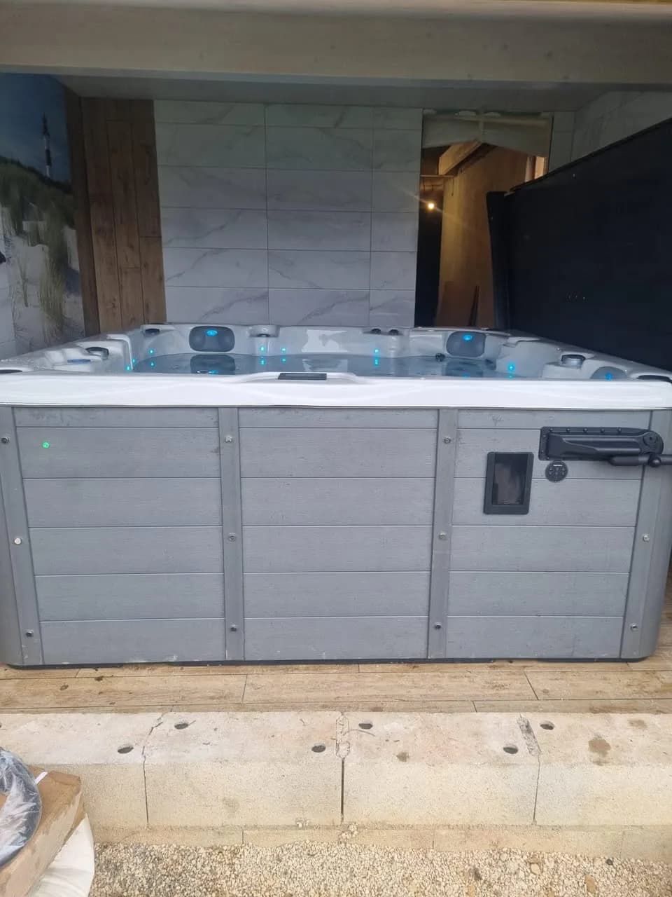 Installation d'un spa Vancouver à Vieux-Ferrette, contre un mur, tablier gris