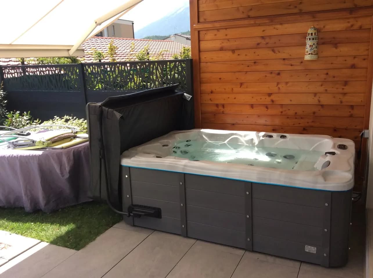 Installation d'un spa Victoria Duel à Gap, sur une terrasse carrelée devant un bardage en bois