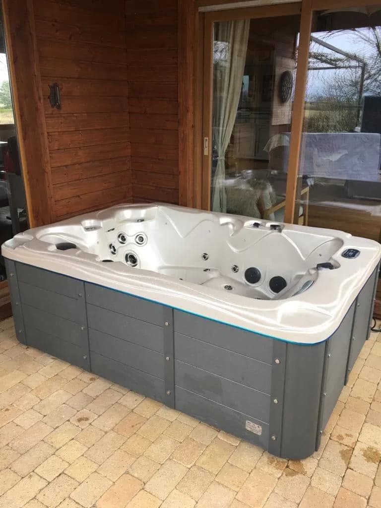 Installation d'un spa Victoria Duel Plug and Play à Coublanc, sous un abri en bois, sol pavé