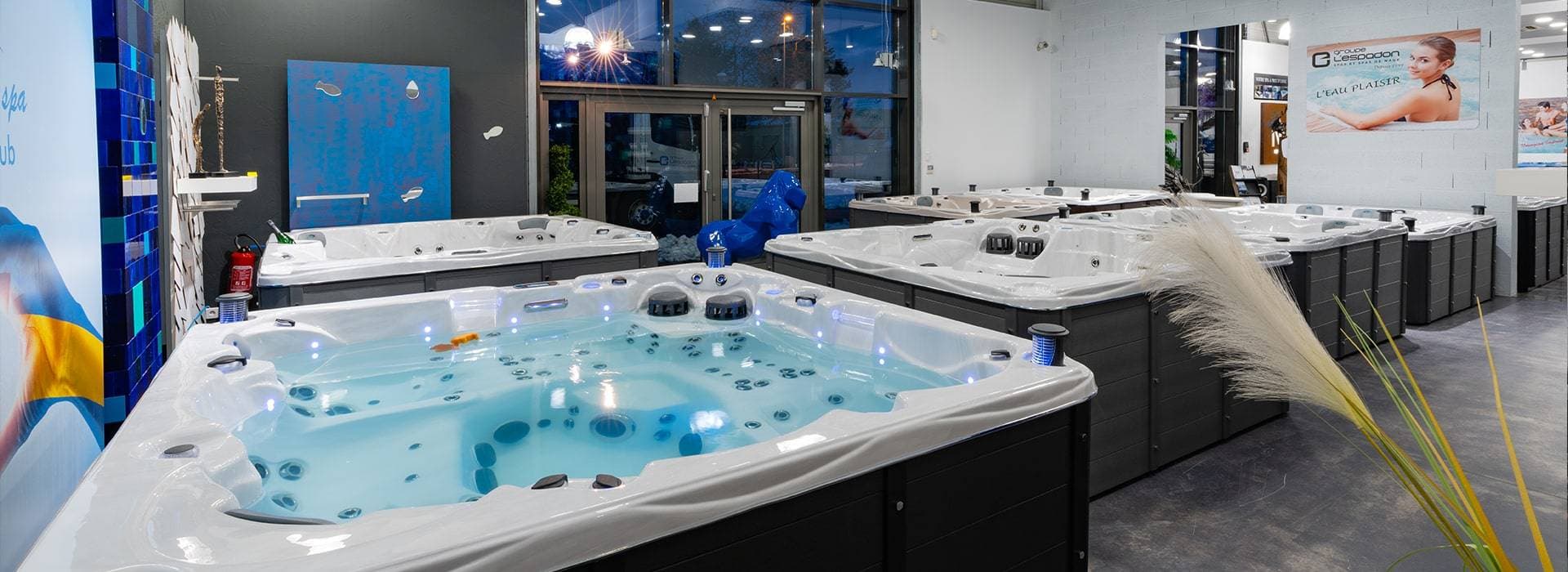 Spas en exposition dans le showroom du Groupe L'Espadon à Richwiller, bassins remplis et éclairés