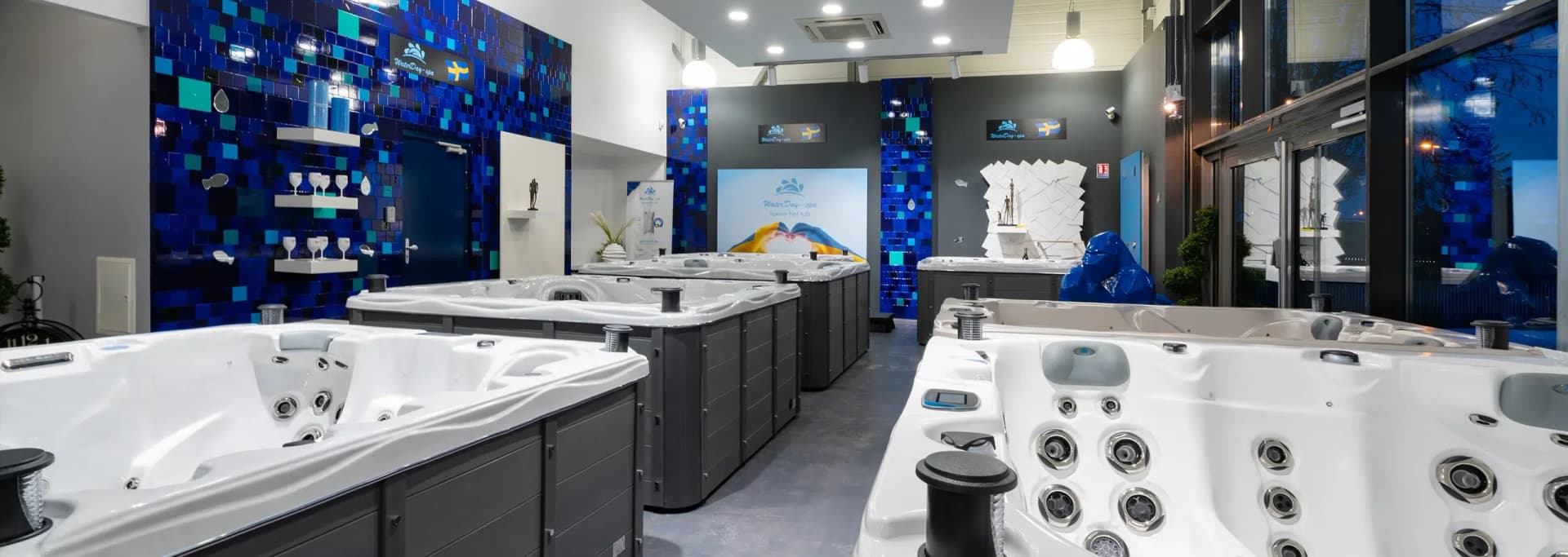 Allée du showroom sous éclairage bleu, spas alignés