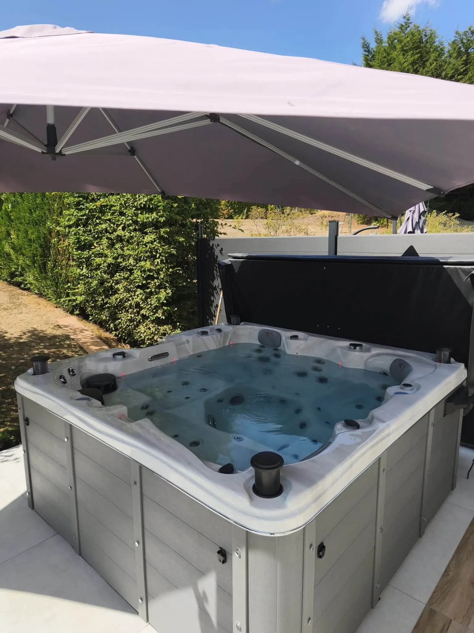 Spa Toronto abrité par un grand parasol déporté, le long d’une haie taillée